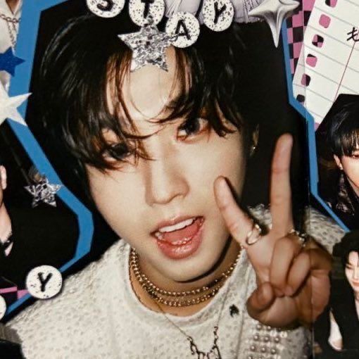 Young K-pop idol with dark hair in white sweater making peace sign, wearing silver jewelry and headpiece