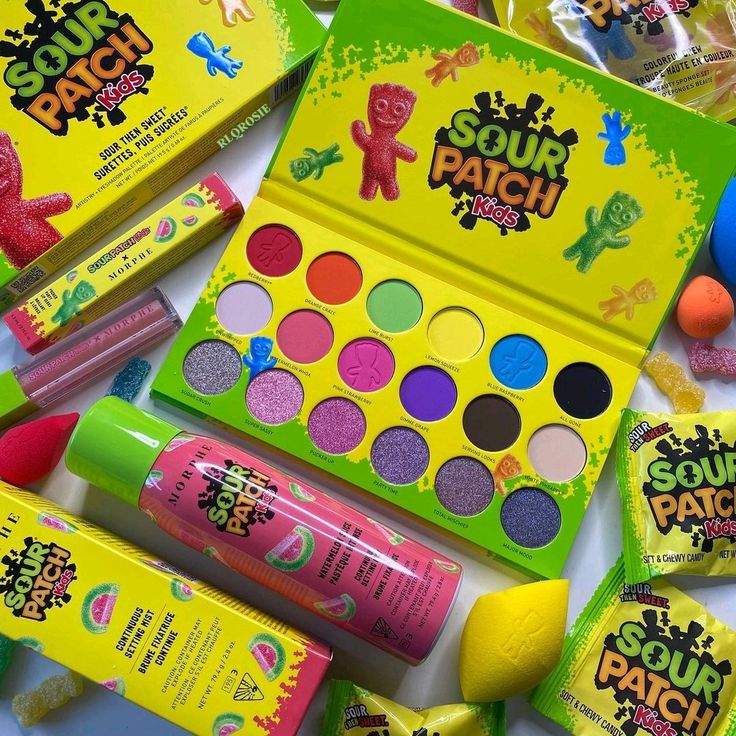 Sour Patch Kids themed makeup palette with colorful eyeshadows and cosmetic products on yellow background
