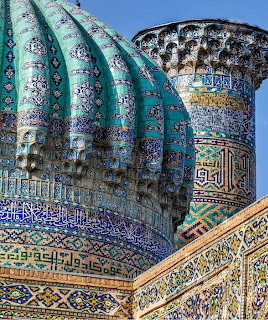 Detailed view of turquoise ribbed dome and decorated minaret with Islamic geometric patterns and calligraphy