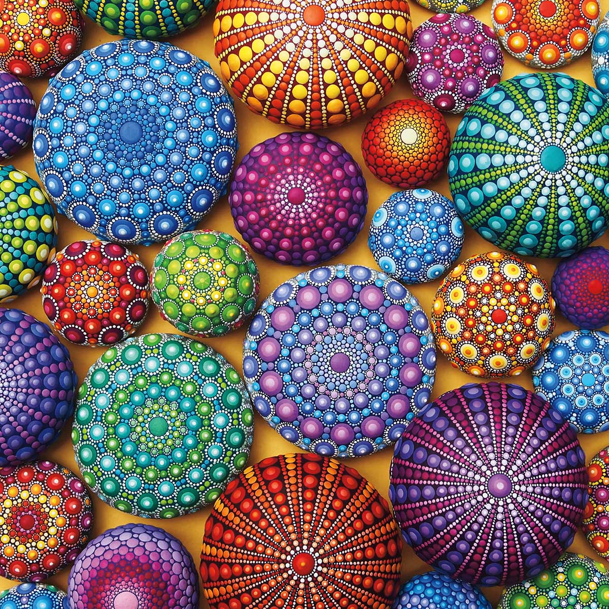 Colorful stones decorated with intricate mandala dot painting patterns in various colors