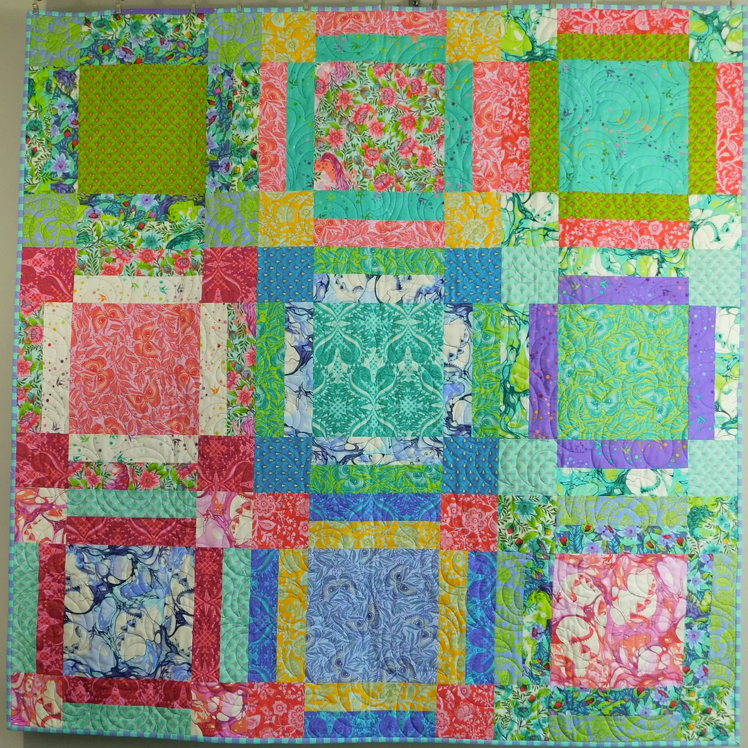 Colorful patchwork quilt with nine squares in floral fabrics and bright multi-colored borders