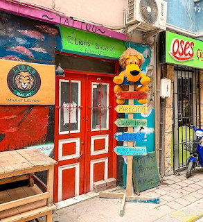 Colorful storefront with red doors, large lion toy, and vibrant painted facade in Istanbul
