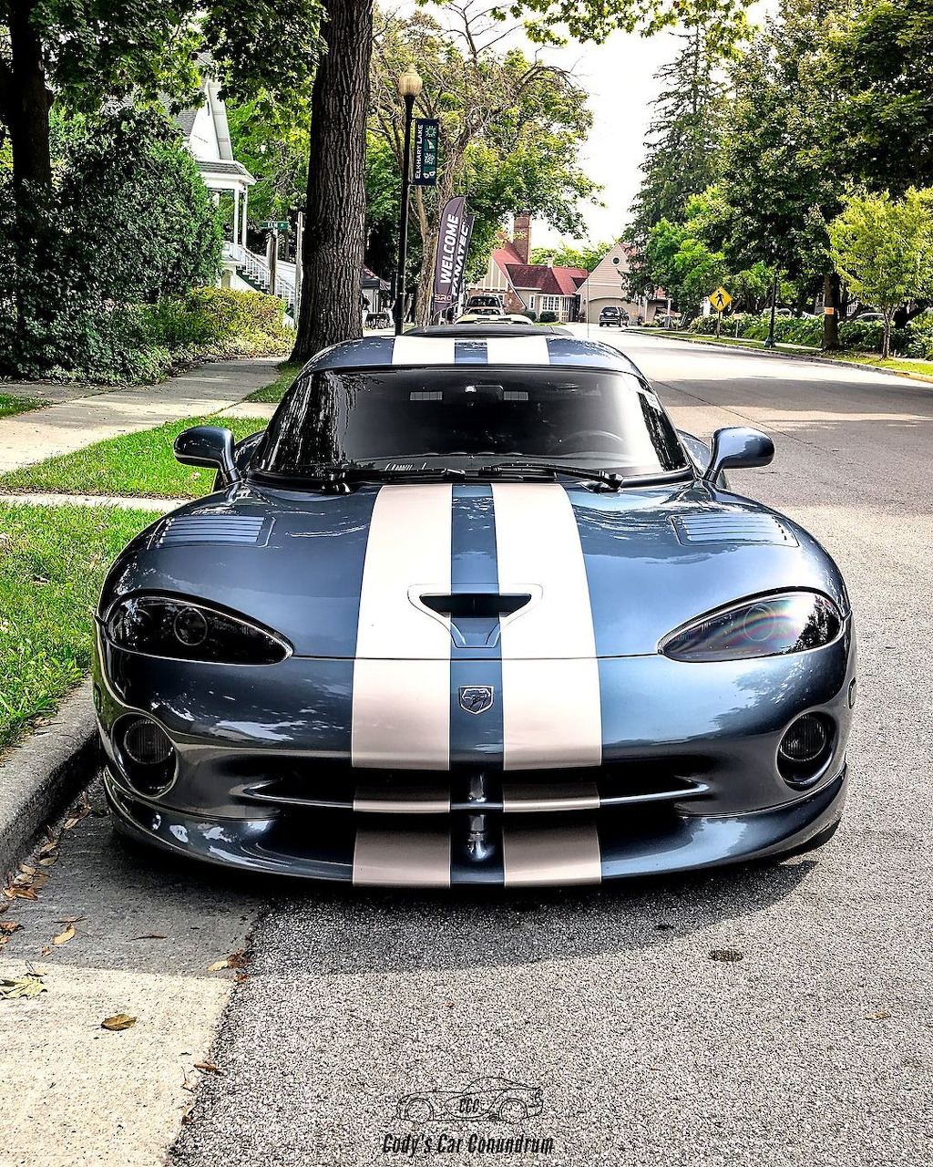 Black Dodge Viper with white racing stripes parked on suburban street