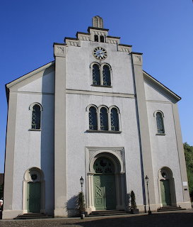 Front facade of Endingen Synagogue in Switzerland with arched windows and pale walls