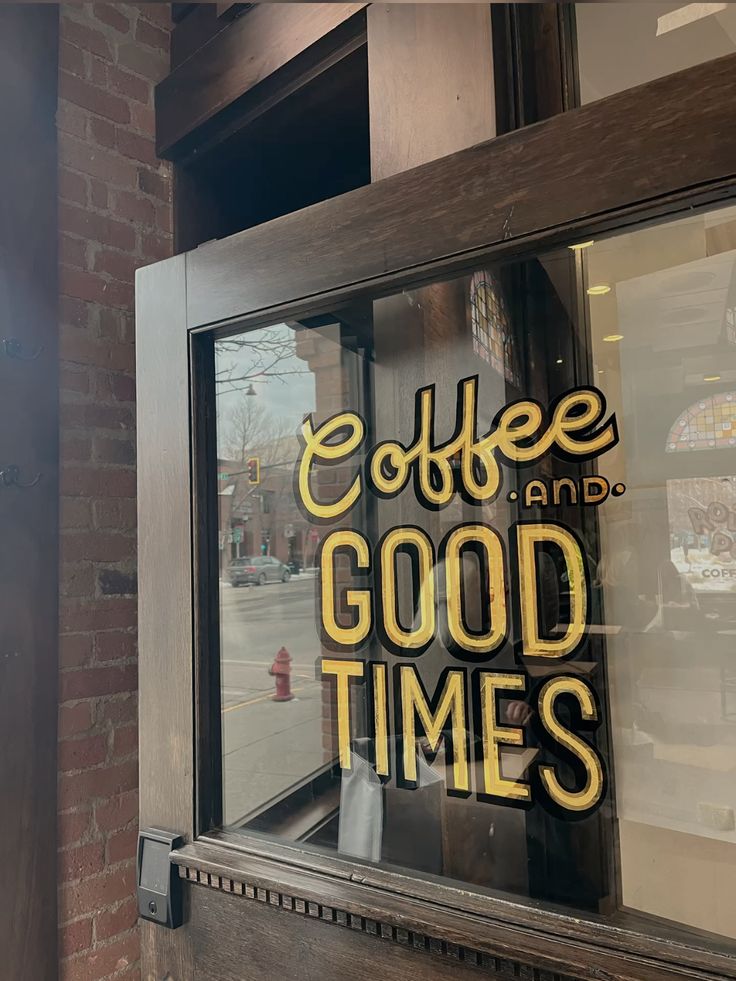 Cafe storefront window with 'Coffee and Good Times' lettered sign in yellow and white