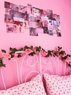 Pink bedroom with white bed, neon heart sign, rose garland, and photo collage wall