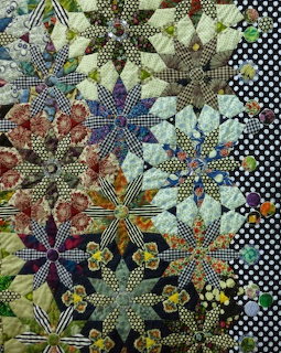 Colorful patchwork quilt with flower motifs made from polka dot and checkered fabric pieces
