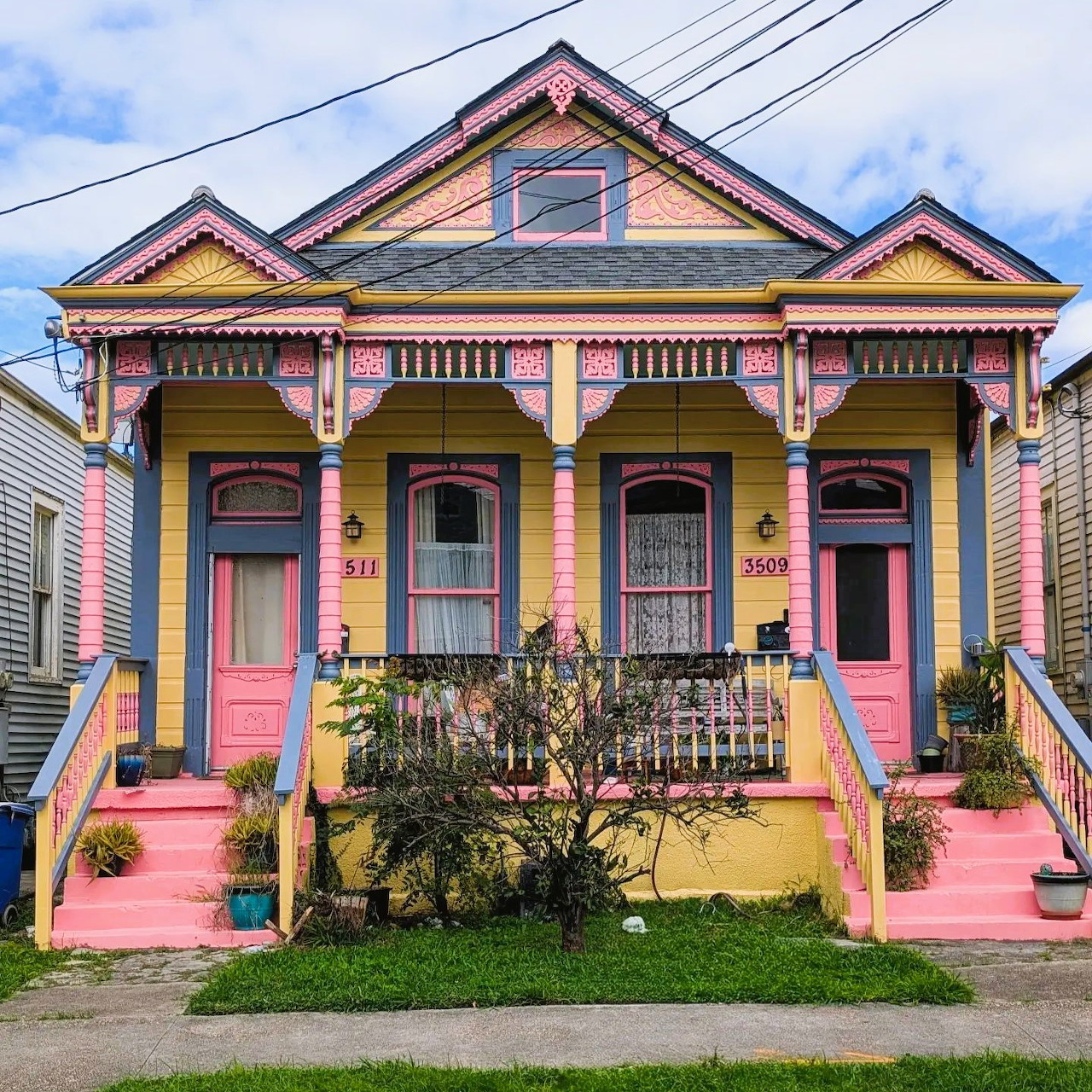 Colorful Victorian house with pink stairs, yellow walls, and purple decorative trim