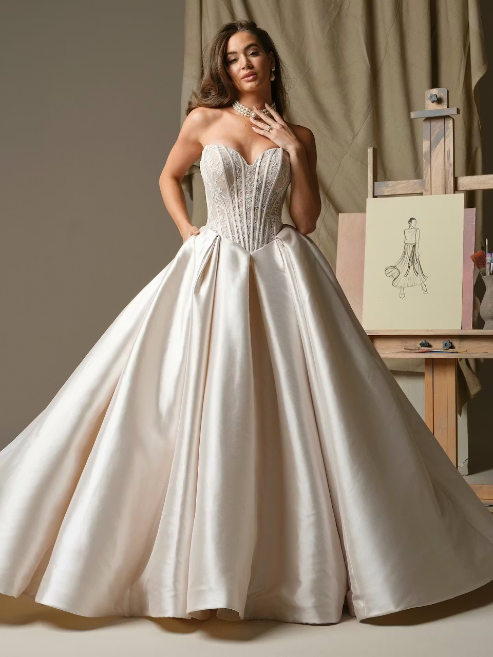Woman in strapless ivory wedding ball gown with corset bodice posing in a studio