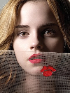 Close-up portrait of woman with brown hair holding red kiss mark cutout near face