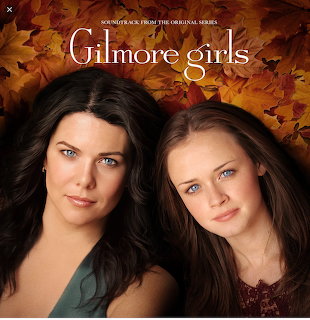 Two women in a Gilmore Girls promotional portrait with autumn leaves in the background
