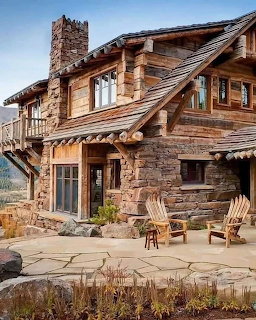 Rustic log and stone mountain house with wooden patio furniture and clear sky