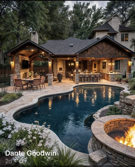 Luxury home backyard with curved pool, stone fire pit, covered patio, and outdoor kitchen at twilight