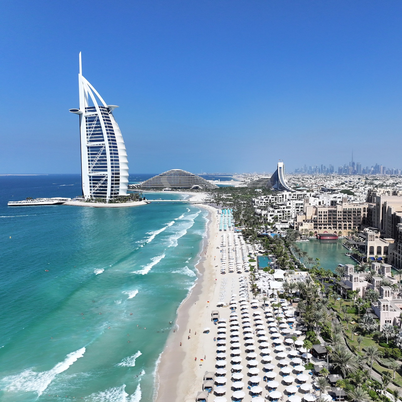 Aerial view of Burj Al Arab hotel on Dubai coastline with beach and turquoise ocean