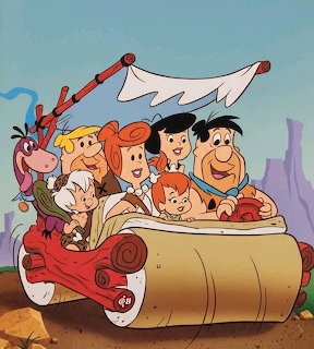 Flintstones cartoon characters in their prehistoric stone car with bone frame canopy