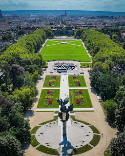 Aerial view of a symmetrical park with formal gardens, lawns, and a monument in Szczecin, Poland