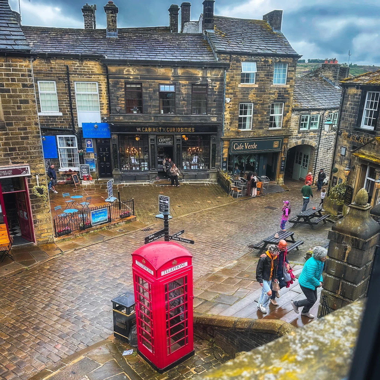Aerial view of cobblestone street in Haworth with red phone box and stone buildings