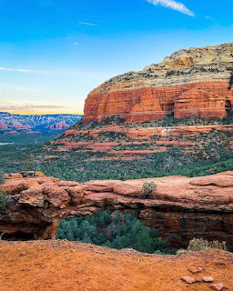 Red rock arch formation above turquoise pool in Sedona desert landscape
