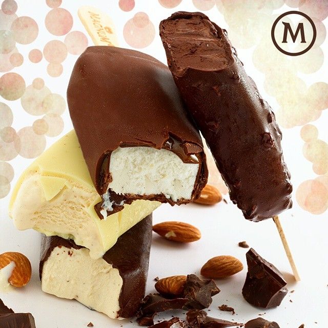 Chocolate-covered vanilla ice cream bars with almonds on pastel dotted background