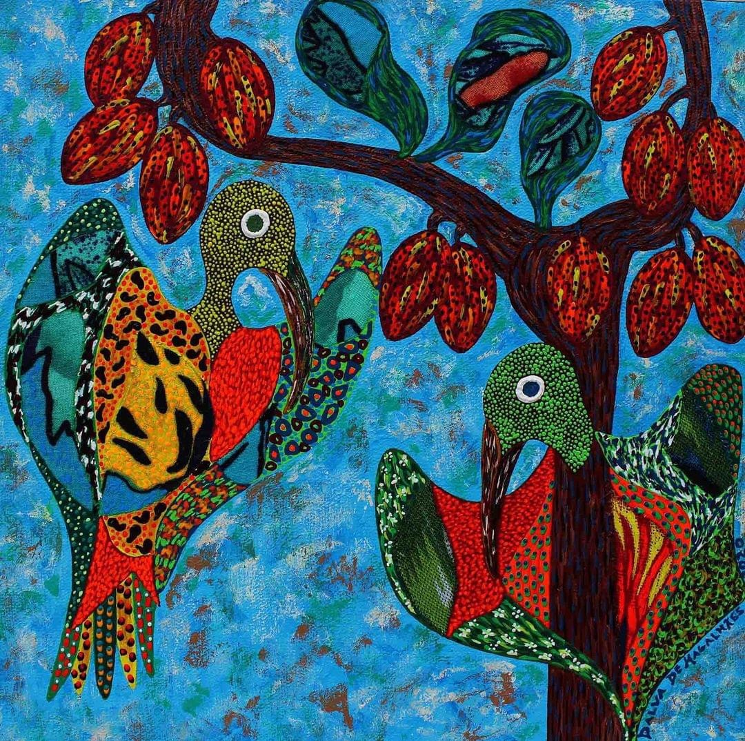 Folk art painting of two ornate birds on a cacao tree with red pods on blue background