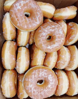 Stack of glazed donuts with white sugar coating