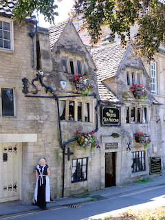 Historic stone tea room building with hanging flower baskets in Bradford-on-Avon, England
