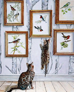 Spotted cat sitting below framed bird illustrations on a marbled wall