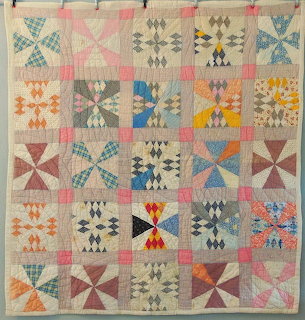 Vintage 1920s quilt with Maltese cross and star block patterns in colorful fabrics on pink background