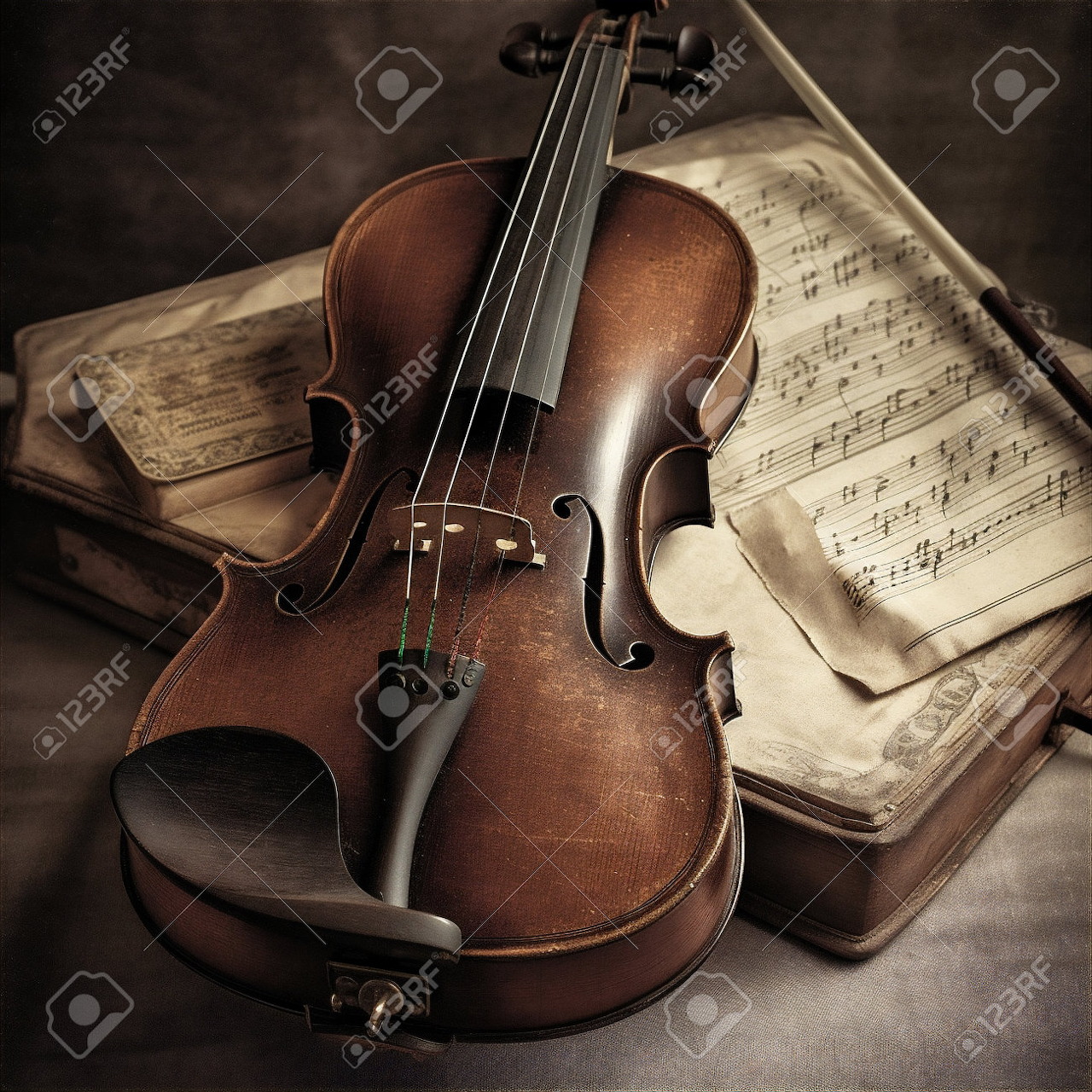 Vintage violin with bow lying on old sheet music pages