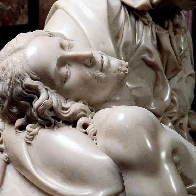 Close-up of Michelangelo's Pieta sculpture showing Christ's face and torso in white marble