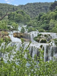 Multi-tiered waterfalls flowing through green forest landscape at Krka National Park, Croatia