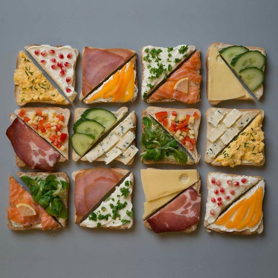 Grid of 12 artfully arranged open-faced sandwich squares with various colorful toppings