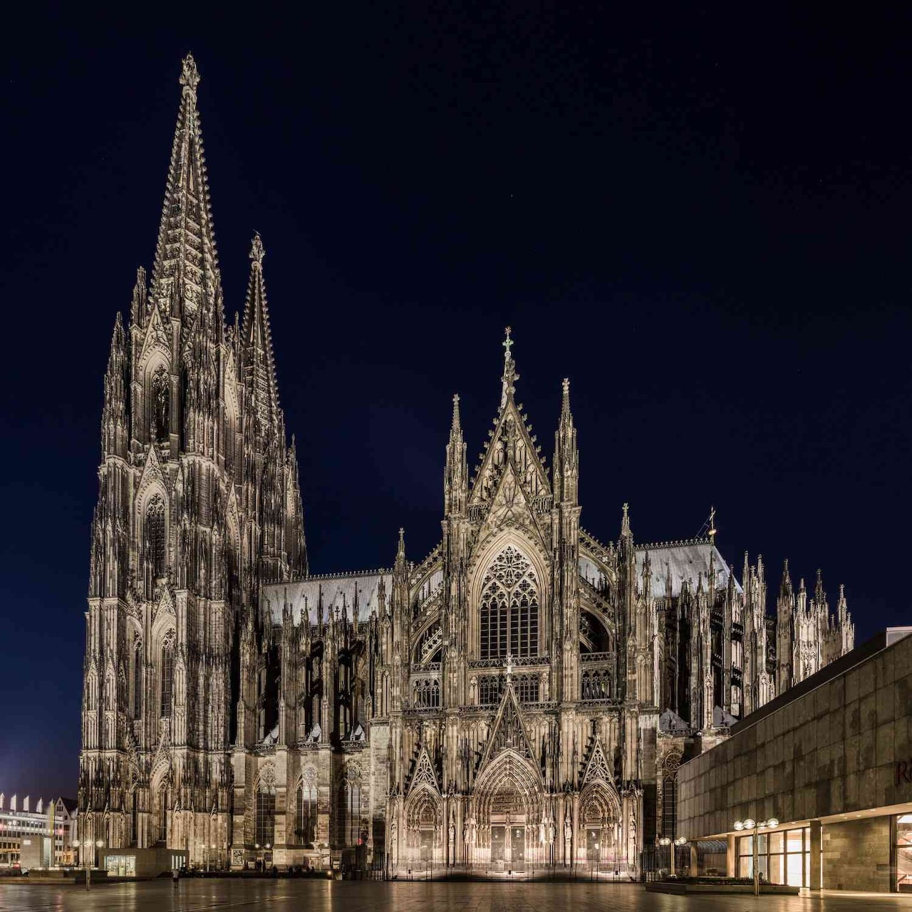 Lit Gothic cathedral with tall spires at night