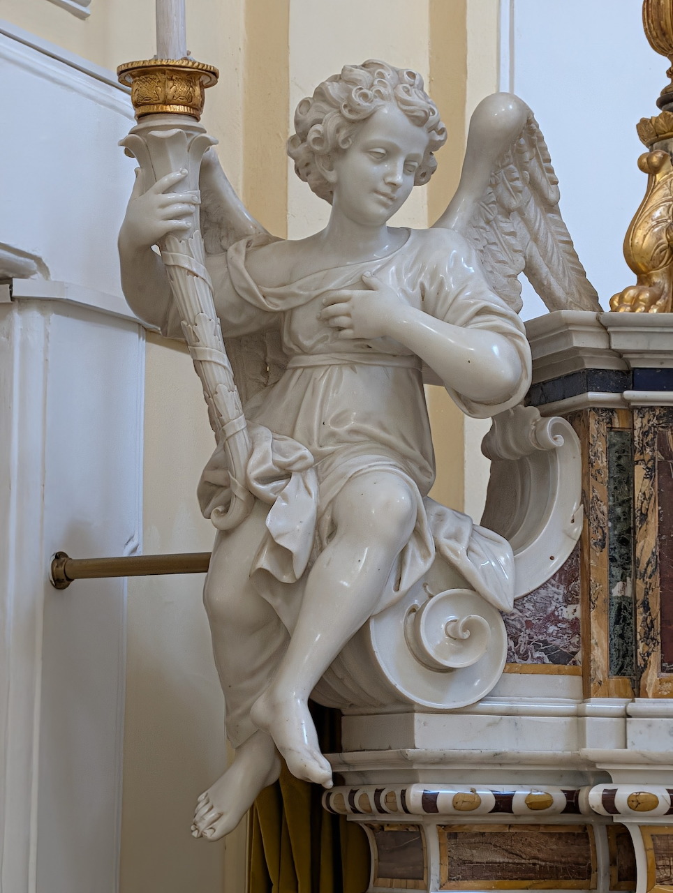 White marble angel statue beside an ornate church pulpit