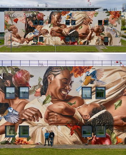 Street art mural on a building wall showing several people in a flowing, painterly composition