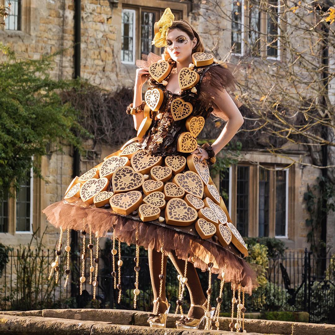 Woman wearing an elaborate dress decorated with heart-shaped cookies outdoors