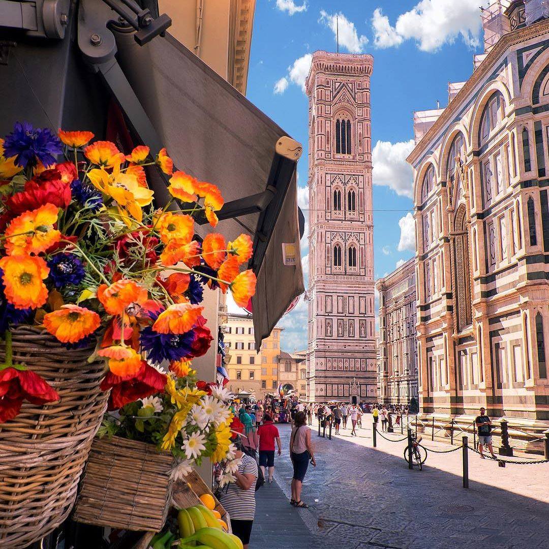 Florence Cathedral bell tower with flower market and historic buildings
