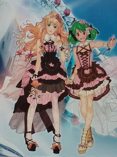 Two anime girls in frilly dresses, one blonde and one green-haired, standing against a blue background.