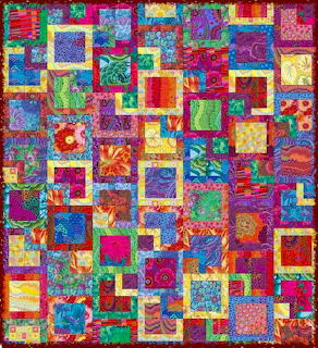 Colorful patchwork quilt with geometric squares and frames in vibrant multicolored fabric patterns