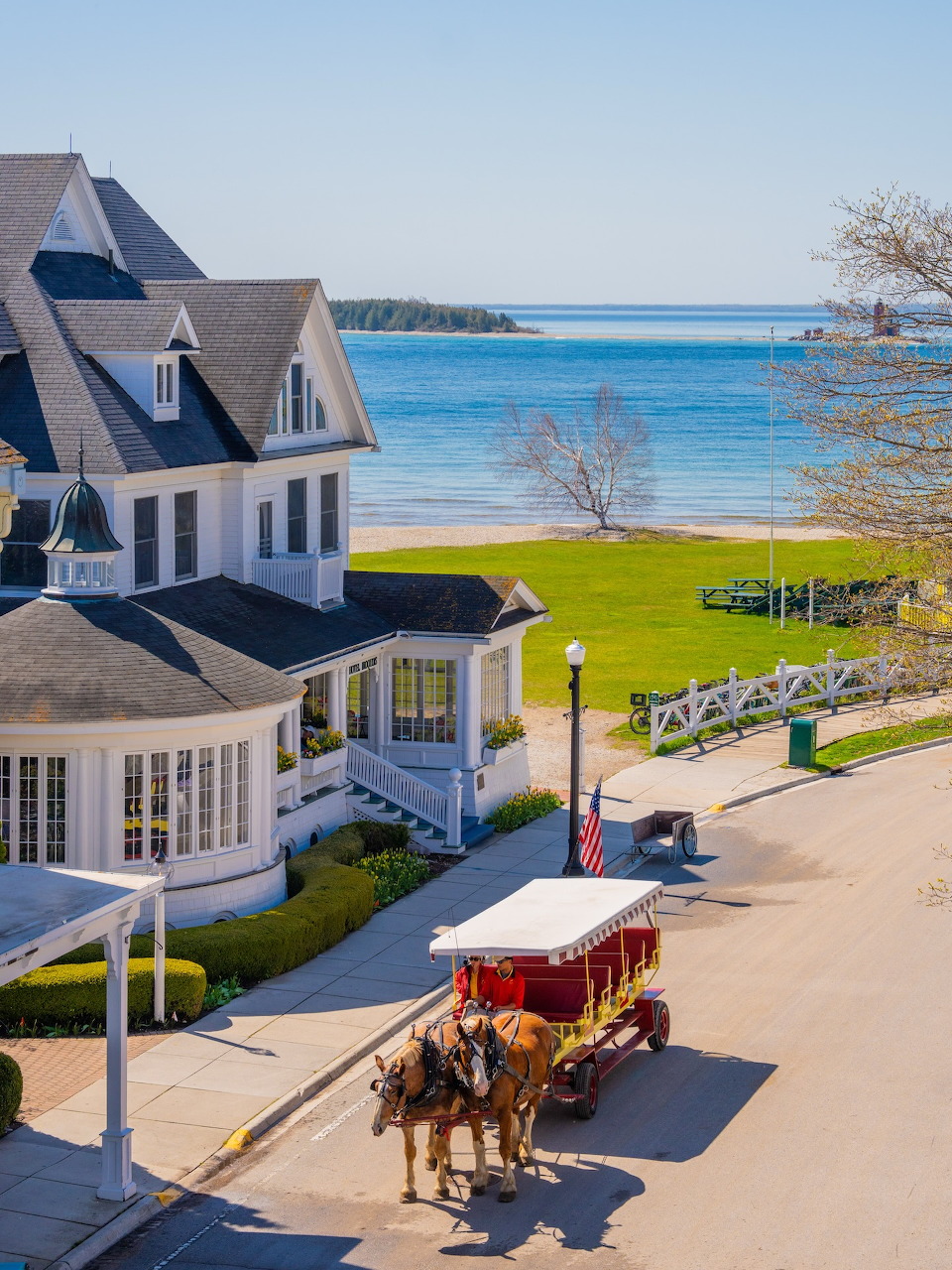 Horse-drawn carriage in front of Hotel Iroquois with lake and beach in background