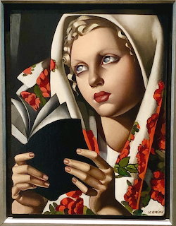 Art Deco painting of blonde woman in white headscarf and floral shawl reading a book