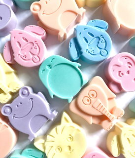 Collection of pastel-colored animal-shaped soaps in pink, blue, green, yellow, and peach tones