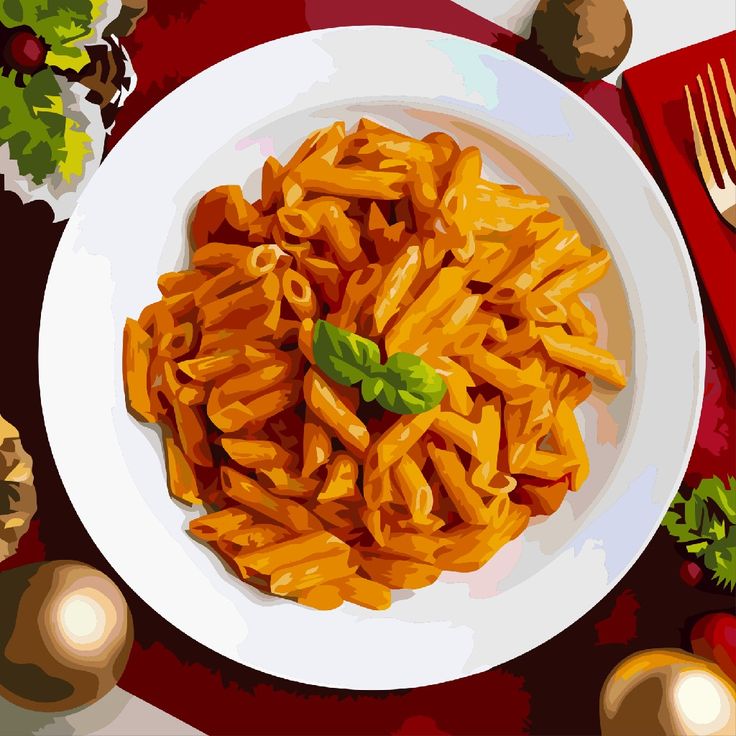Top view of penne pasta on a white plate with basil garnish on a red table