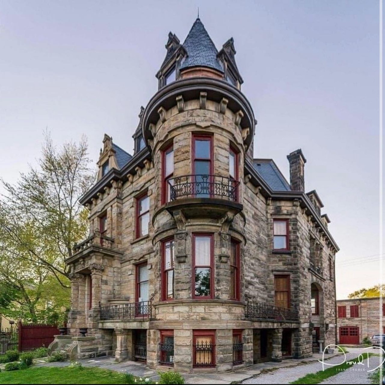 Historic stone mansion with a turret, ornate windows, and steep roofs