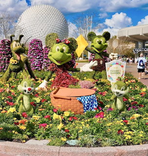 Mickey Mouse shaped topiary sculptures made of plants and flowers with Epcot sphere in background
