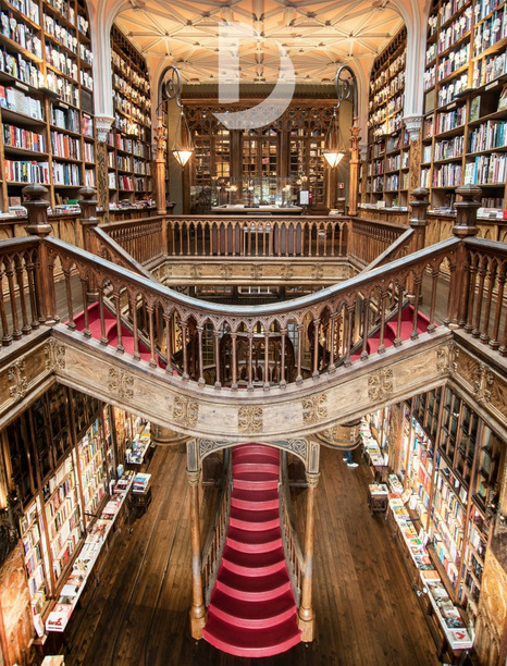 Grand interior of Livraria Lello bookstore in Porto with red spiral staircase and floor-to-ceiling bookshelves