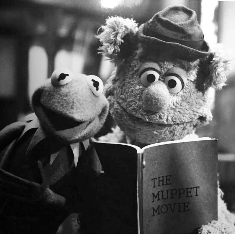 Black-and-white image of Kermit the Frog and Fozzie Bear reading The Muppet Movie book