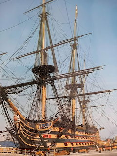 Historic HMS Victory sailing ship docked with tall masts and rigging