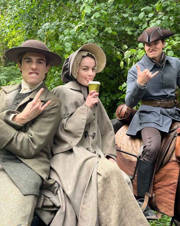 Outlander series characters in Highland clothing against a moody landscape backdrop.