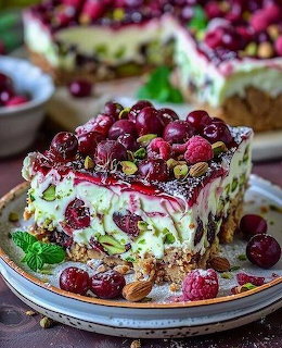Slice of berry cream cake with cherries and raspberries on a plate